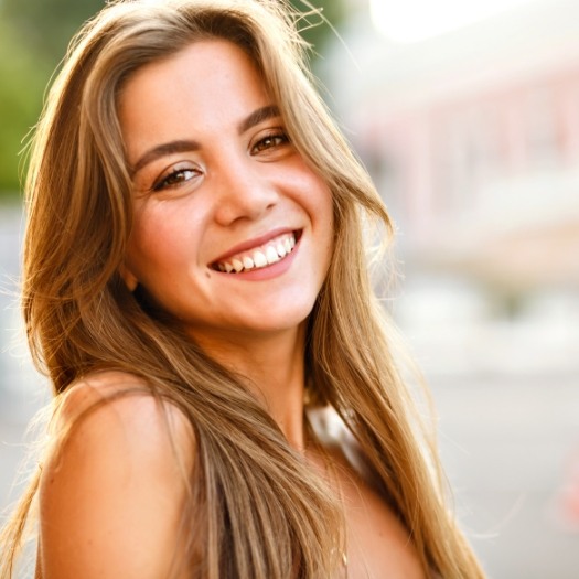 Young woman grinning outdoors