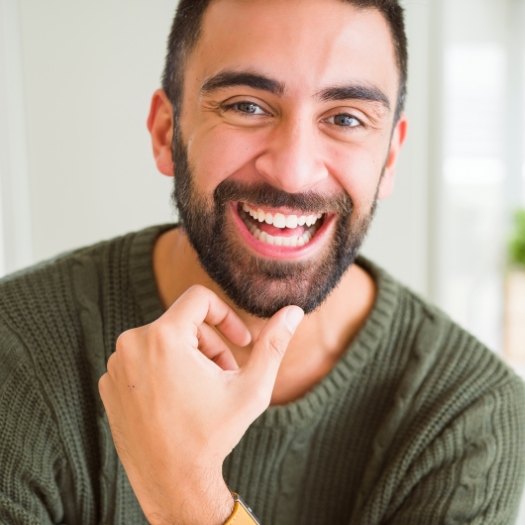 Man in green sweater smiling after safe amalgam filling removal in San Antonio