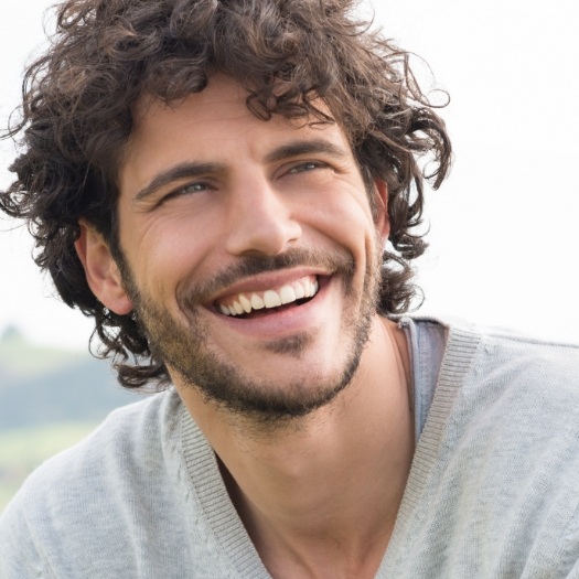 Smiling young man with curly brown hair