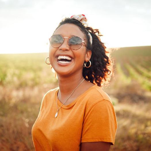 Happy, smiling woman standing outdoors
