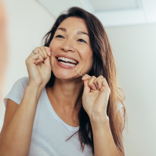 Woman flossing her teeth