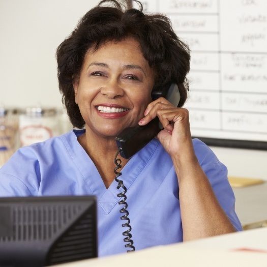 Smiling dental team member talking on phone