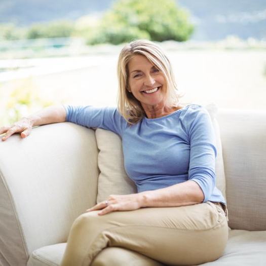 Confident, mature woman sitting on sofa
