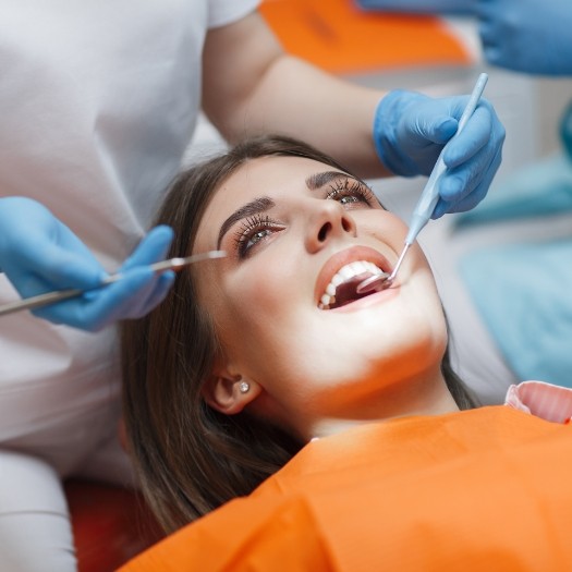 Woman having her mouth examined by dentist