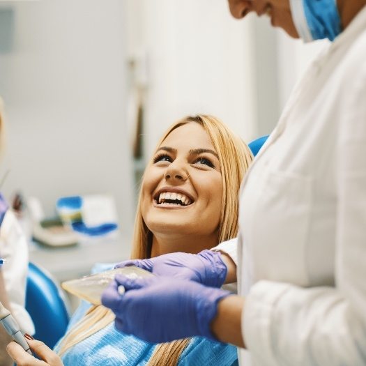 Woman in dental chair smiling at her dentist