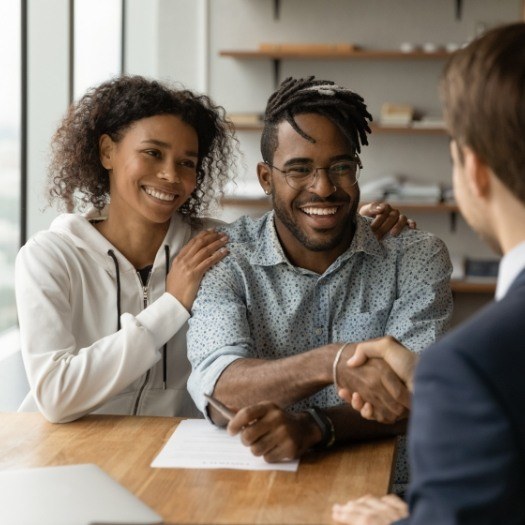 Man shaking hands with someone across desk