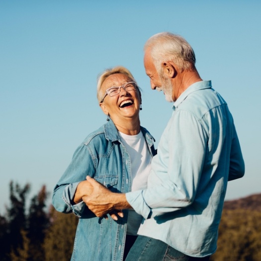 Senior man and woman dancing outdoors together