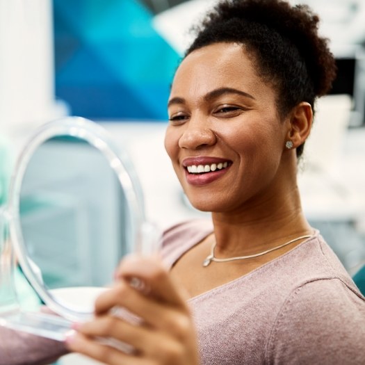 Dental patient looking at her smile in a mirror