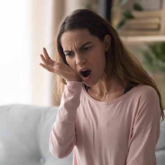 Woman holding her jaw in pain before T M J treatment in San Antonio