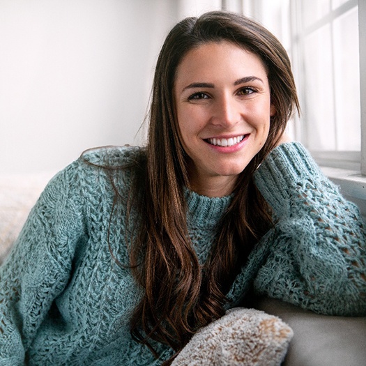 Woman with beautiful teeth posing on her sofa