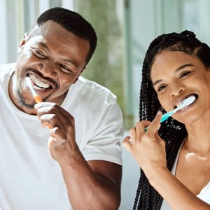 Happy couple brushing their teeth