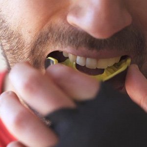 Man placing mouthguard into his mouth