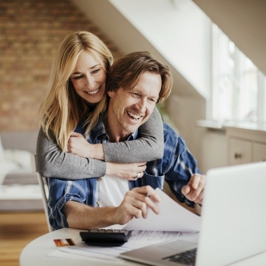 Man and woman looking at laptop for dentist reviews in San Antonio