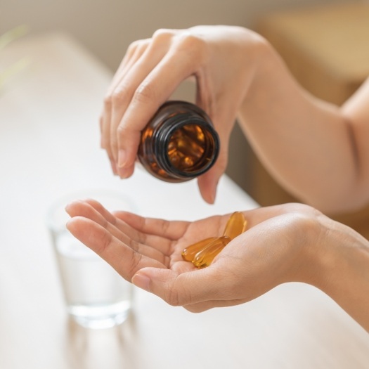 Person pouring pills out of a bottle and into their hand