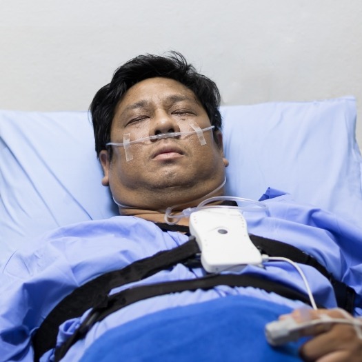 Sleeping man in hospital bed with cannula in his nose