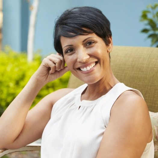 Woman in sleeveless white blouse smiling