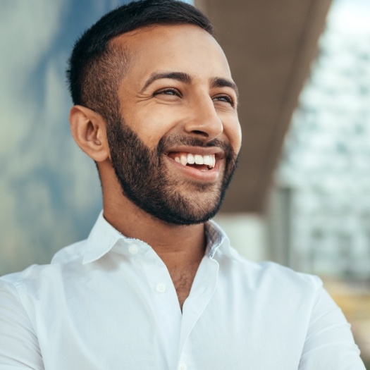 Man in white collared shirt smiling thanks to Invisalign in San Antonio