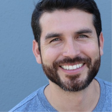 Man with beard and blue shirt grinning