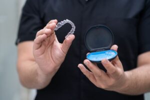 Dental professional holding Invisalign aligner 